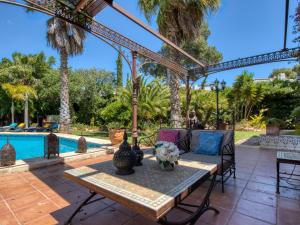 a patio with a table and chairs and a pool at Villa Villa Adelfa by Interhome in Jávea