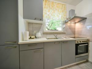 a kitchen with white cabinets and a sink and a window at Apartment Sandra by Interhome in Matulji