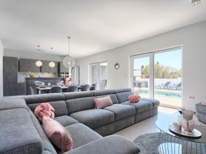 a living room with a gray couch with pink pillows at Villa Ella Premantura by Interhome in Pula