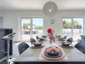 a dining room with a table with plates and wine glasses at Villa Ella Premantura by Interhome in Pula