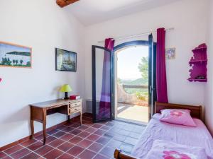 um quarto com uma cama, uma secretária e uma janela em Villa Les Baux Rouges by Interhome em Solliès-Ville