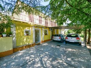 two cars parked in front of a yellow building at Apartment Sandra by Interhome in Matulji