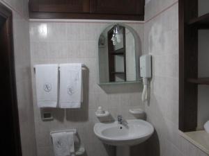 a bathroom with two sinks and a mirror at Hotel Columbia in Palermo