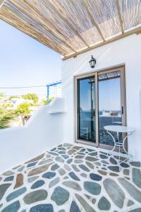 a patio with a table and a view of the ocean at Porto Bello Tinos in Agios Ioannis