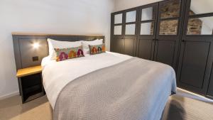 een slaapkamer met een groot wit bed met kussens bij Linton Collection - Blackfriars Lofts in Edinburgh