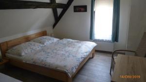 a bedroom with a bed and a window and a table at Penzion Sklář in Nový Bor