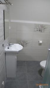 a white bathroom with a sink and a toilet at Penzion Sklář in Nový Bor
