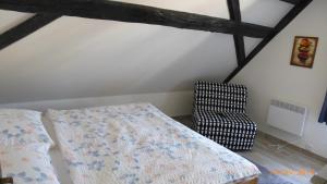 a bedroom with a bed and a chair at Penzion Sklář in Nový Bor