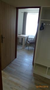 a hallway with a room with a table and a door at Penzion Sklář in Nový Bor
