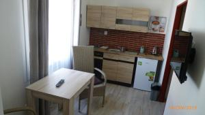 a small kitchen with a table and a refrigerator at Penzion Sklář in Nový Bor