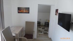 a dining room with a table and a television at Penzion Sklář in Nový Bor