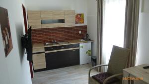 a small kitchen with a sink and a refrigerator at Penzion Sklář in Nový Bor