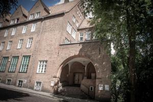 a large brick building with an archway in front of it at Boardinghouse Flensburg - by Zimmer FREI! Holidays in Flensburg
