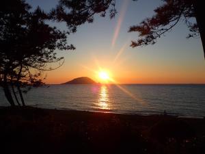 福岡的住宿－Kyukamura Shikanoshima，海上的日落,背景是山