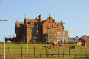 an old building with a fence in front of it at Adamton Country House Hotel in Prestwick
