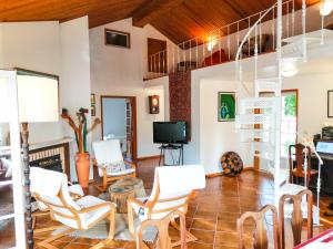 a living room with white chairs and a tv at Casa da Balseira in Aveiro