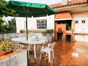 a table and chairs with an umbrella on a patio at Casa da Balseira in Aveiro
