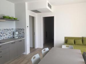 a white kitchen with a table and a couch at Appartamenti Morele in Tignale