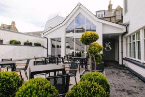 a patio area with chairs, tables, and umbrellas at The Seafield Arms-Cullen in Cullen