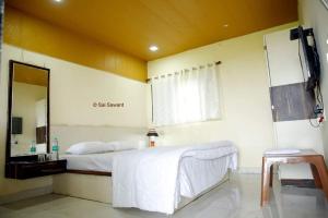 a bedroom with a large bed and a mirror at Malvan Katta in Satara