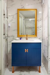 a bathroom with a blue vanity and a mirror at Güner Business Hotel in Istanbul