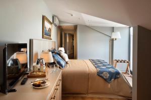 een slaapkamer met een bed en een bureau met een televisie bij Güner Business Hotel in Istanbul