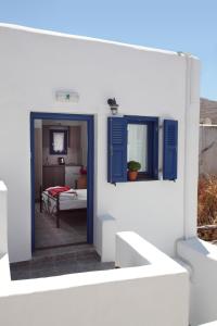 a view of a room with blue doors and a bedroom at Margarita's Rooms in Chora Folegandros