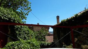 una casa con una valla roja y hiedra en Gîtes chez Daniel "Cevennes 1", en Mars