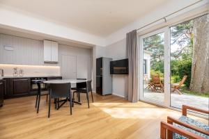 a kitchen and living room with a table and chairs at Vila prie jūros in Palanga