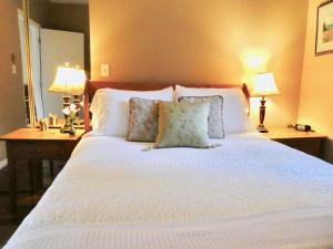 a bedroom with a large white bed with two lamps at Belle Neige Whistler in Whistler