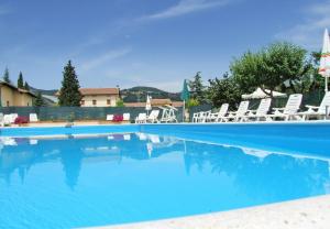 a large swimming pool with chairs and blue water at Agriturismo Casella Del Piano in Gubbio