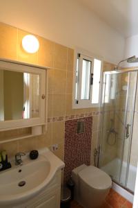 a bathroom with a sink and a toilet and a shower at The Paradise Townhouses By Taimoura in Paphos City