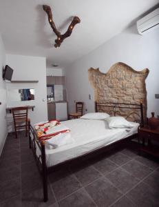 1 dormitorio con 1 cama grande y pared de piedra en Margarita's Rooms, en Chora Folegandros