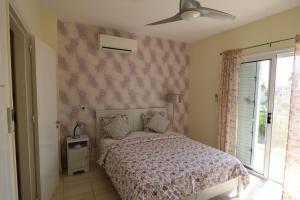 a bedroom with a bed and a ceiling fan at The Paradise Townhouses By Taimoura in Paphos City