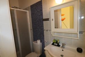 Un baño con inodoro, lavabo y espejo. en The Paradise Townhouses By Taimoura, en Pafos 63 fotos más