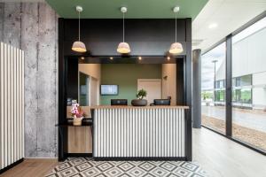 an office lobby with a reception desk and large windows at B&B HOTEL Cergy Saint Christophe in Cergy