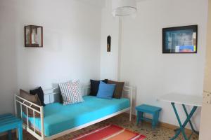 a room with a blue couch and a table at Aumkara in Skala Eresou