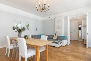 a dining room with a table and a couch at Modern History Apartment in Tallinn