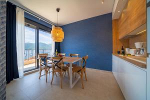 a kitchen and dining room with a table and chairs at Sealine Apartments A2 in Tivat