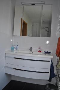 ein Badezimmer mit einem weißen Waschbecken und einem Spiegel in der Unterkunft gemütliche Zimmer im Einfamilienhaus in Köln
