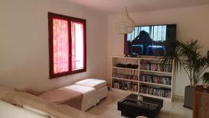 Una sala de estar con un sofá y un televisor. en Villa janas, en La Seyne-sur-Mer