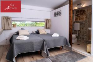 1 dormitorio con 1 cama con toallas en Guest House Almeixar en Almancil