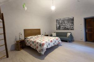 ein Schlafzimmer mit einem Bett und einem Sofa in der Unterkunft La Pitta in Gattinara