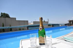 a bottle of champagne on a table near a swimming pool at A Royal Luxury Villa In Center With Two Swimming Pools, Sauna and Jacuzzi. in Yerevan