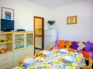 una sala da pranzo con tavolo e divano di Villaggio Azzurro a Bibione