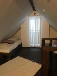 een zolderkamer met 2 bedden en een raam bij Domek na skarpce in Zakopane