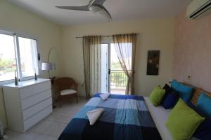 Un dormitorio con una cama con almohadas azules y verdes. en The Paradise Townhouses By Taimoura, en Pafos