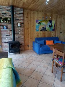 a living room with a blue couch and a fireplace at Chalet del Laghetto in Chiusa di Pesio