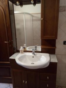 a bathroom with a white sink and a mirror at Chalet del Laghetto in Chiusa di Pesio