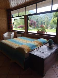 a bedroom with a bed and a large window at Chalet del Laghetto in Chiusa di Pesio